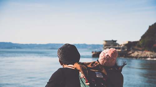 apparel man and woman facing body of water clothing