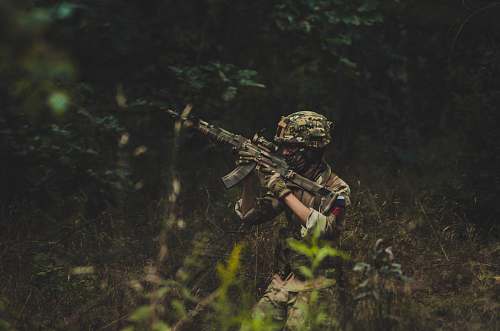 military man pointing assault rifle near trees sniper