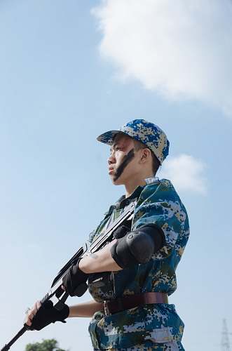 person man standing carrying rifle during day military