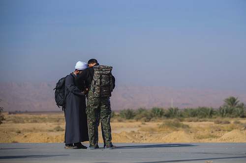apparel man wearing camouflage soldier uniform besides man wearing white turban clothing