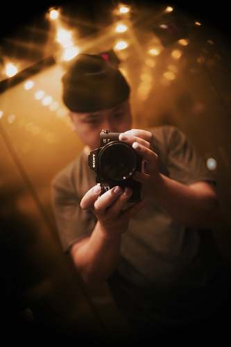 person man wearing gray holding camera camera