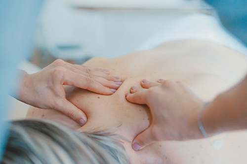 person person massaging the back of a woman massage