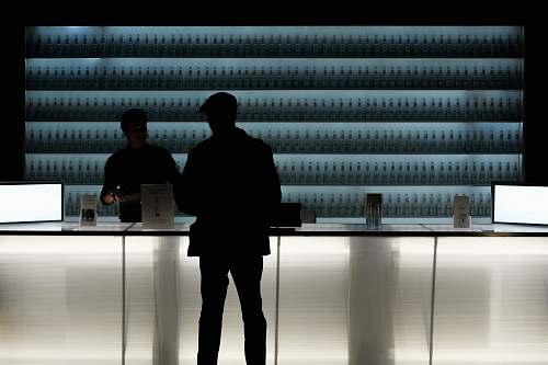 person silhouette of man standing near glass counter top furniture