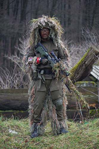 sniper soldier covered with grass holding sniper rifle military