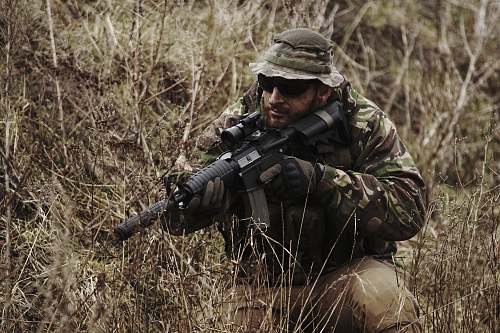 person soldier holding black assault rifle people