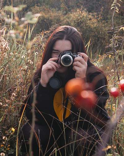 person woman holding camera on field camera