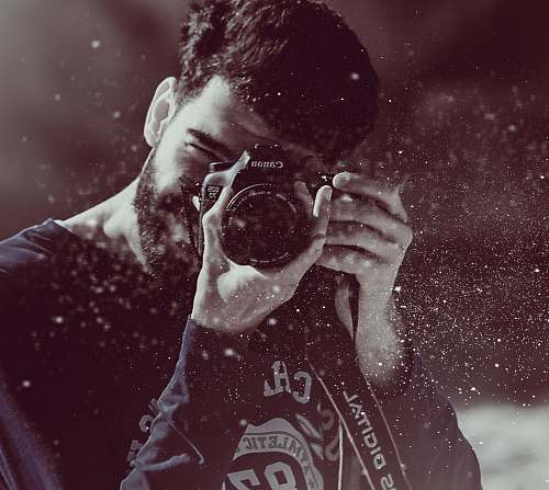 man photography of person taking photo using Canon camera guy