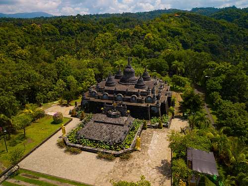 outdoors aerial photography of gray and brown concrete building surrounded by green trees scenery