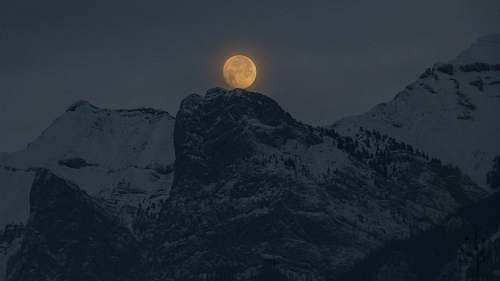 outdoors full moon over a snowy mountain top night