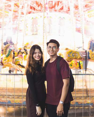 person smiling man beside woman near horse carousel human