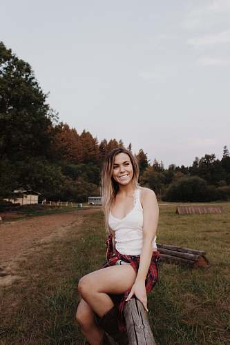 person woman sitting on wood fence during daytime human