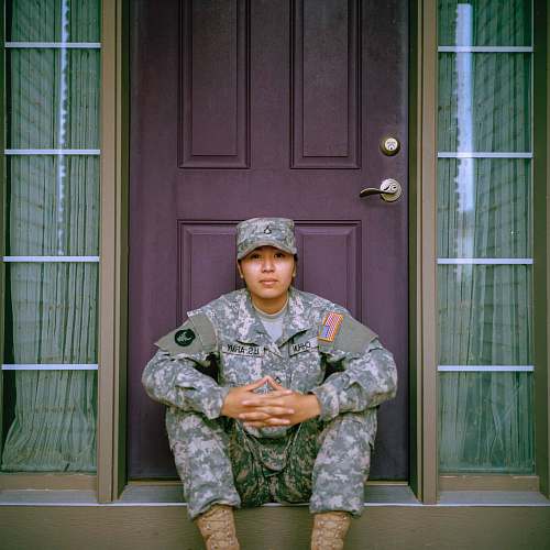 military woman sitting in front of closed door door