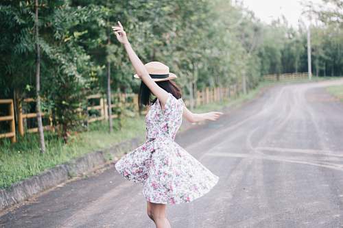 people woman wearing white floral dress standing on concrete road human