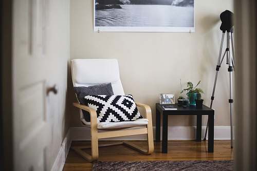 chair throw pillow on chair beside end table inside room furniture