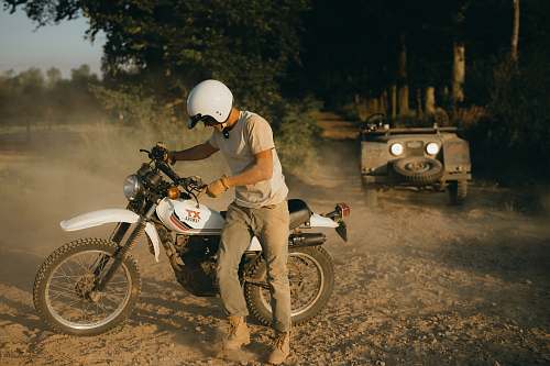 transportation man standing beside white standard motorcycle motorcycle