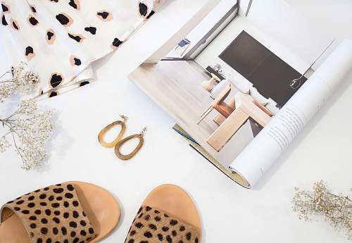 apparel sandals and earrings placed next to opened catalog fashion