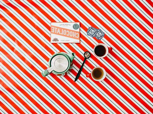 hole cup of coffee on red and white striped surface flat aly