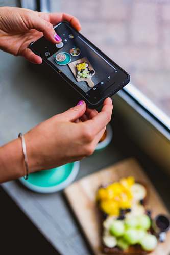 phone person taking photo of food cell phone