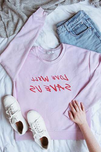 human pink long-sleeved shirt on white textile near white low-top sneakers and blue denim bottoms people
