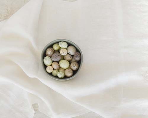 food pebbles in gray ceramic bowl on white textile produce