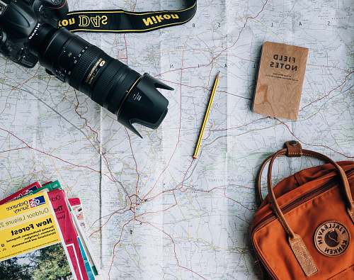 pencil flat lay photography of camera, book, and bag notebook