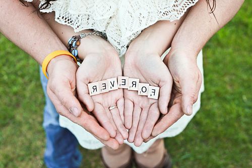 adult and girl holding forever scrabble letters during daytime