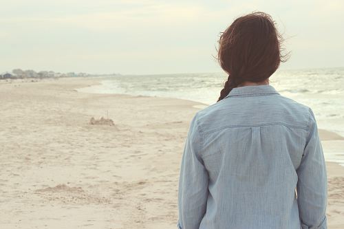 back view of woman standing near sea