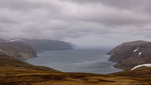 body of water under cloudy sky