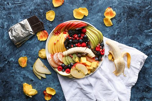 bowl of sliced fruits on white textile