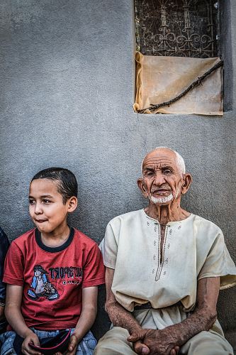 boy sitting next to a man