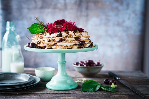 cake on cake stand beside milk on milk bottles