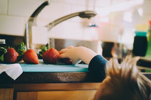 child picking strawberries in kitchen