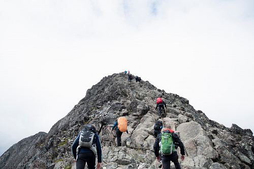 climbers hiking through mountain peak during daytime