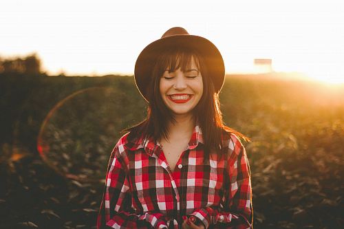 golden hour photography of woman in red and white checkered dress shirt