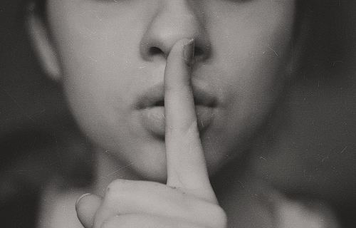 grayscale photo of woman doing silent hand sign