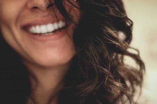 long black haired woman smiling close-up photography