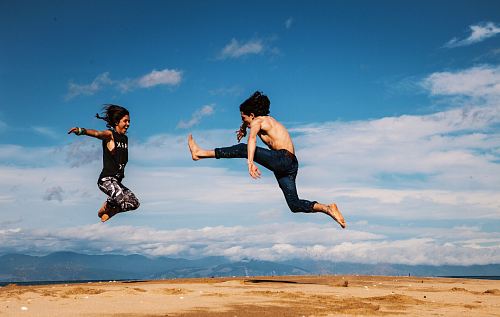 man and woman hanging on blue and white sky