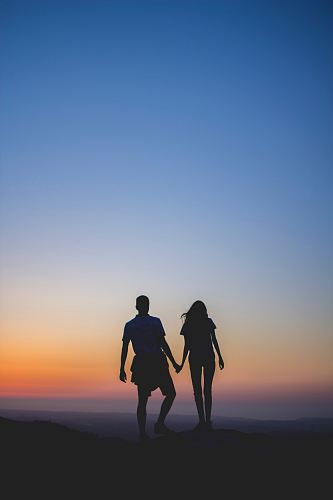 man and woman holding hands in silhouette photography