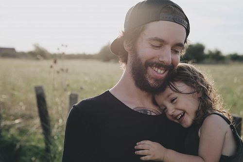 man carrying daughter in black sleeveless top