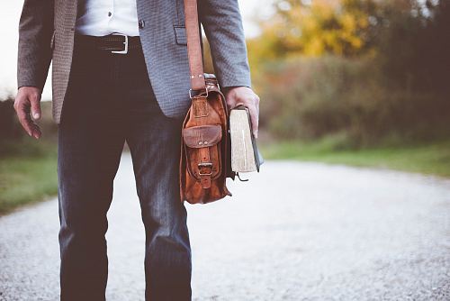 man holding book on road during daytime