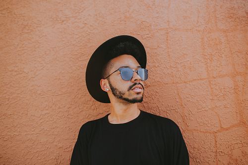 man leaning on brown wall