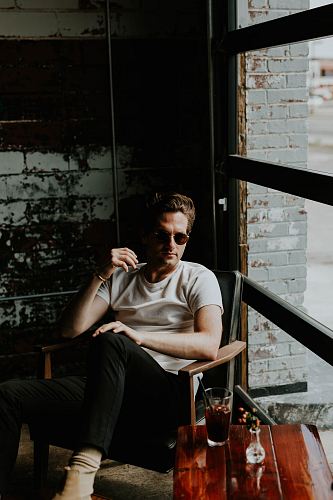 man sitting on a armchair beside window