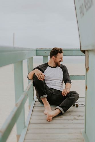 man smiling while sitting on floor during daytime