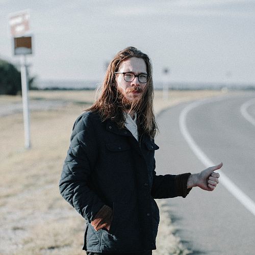 man standing near road during daytime