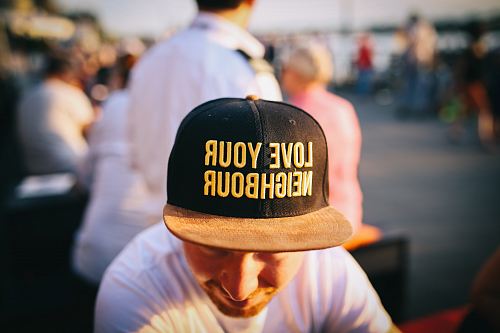 man wearing black cap with love your neighbour print during daytime
