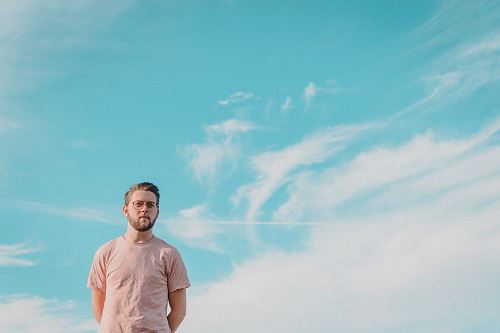 man wearing pink t-shirt and eyeglasses