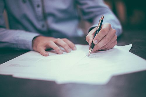 man writing on paper