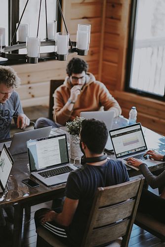 men sitting in front of their laptop computer