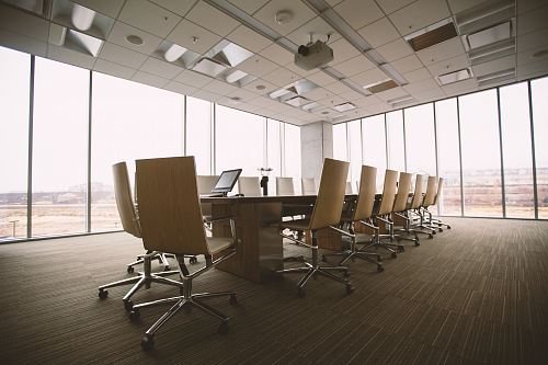 oval brown wooden conference table and chairs inside conference room