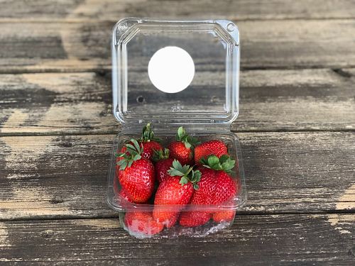pack of strawberries on brown wooden surface